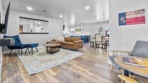 A modern living room with a sofa, armchairs, a coffee table, and a rug.