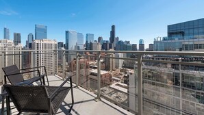 A balcony with a city view overlooking high-rise buildings.