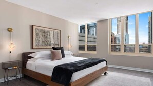 Une chambre moderne avec un grand lit, une vue sur la ville et un décor minimaliste.