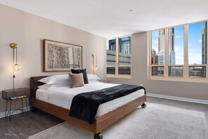A modern bedroom with a large bed, city view, and minimalist decor. - Luxury Meets Fun: Downtown PH w/ Private Game Room (Chicago)