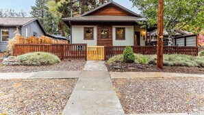 A two-story house with a front porch, a wooden fence, and a gravel driveway. - Cozy Pet-Friendly Cottage Near Downtown Bend (Bend)