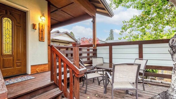 A wooden deck with outdoor furniture, a wooden staircase, and a door with a stained glass window. - Cozy Pet-Friendly Cottage Near Downtown Bend (Bend)