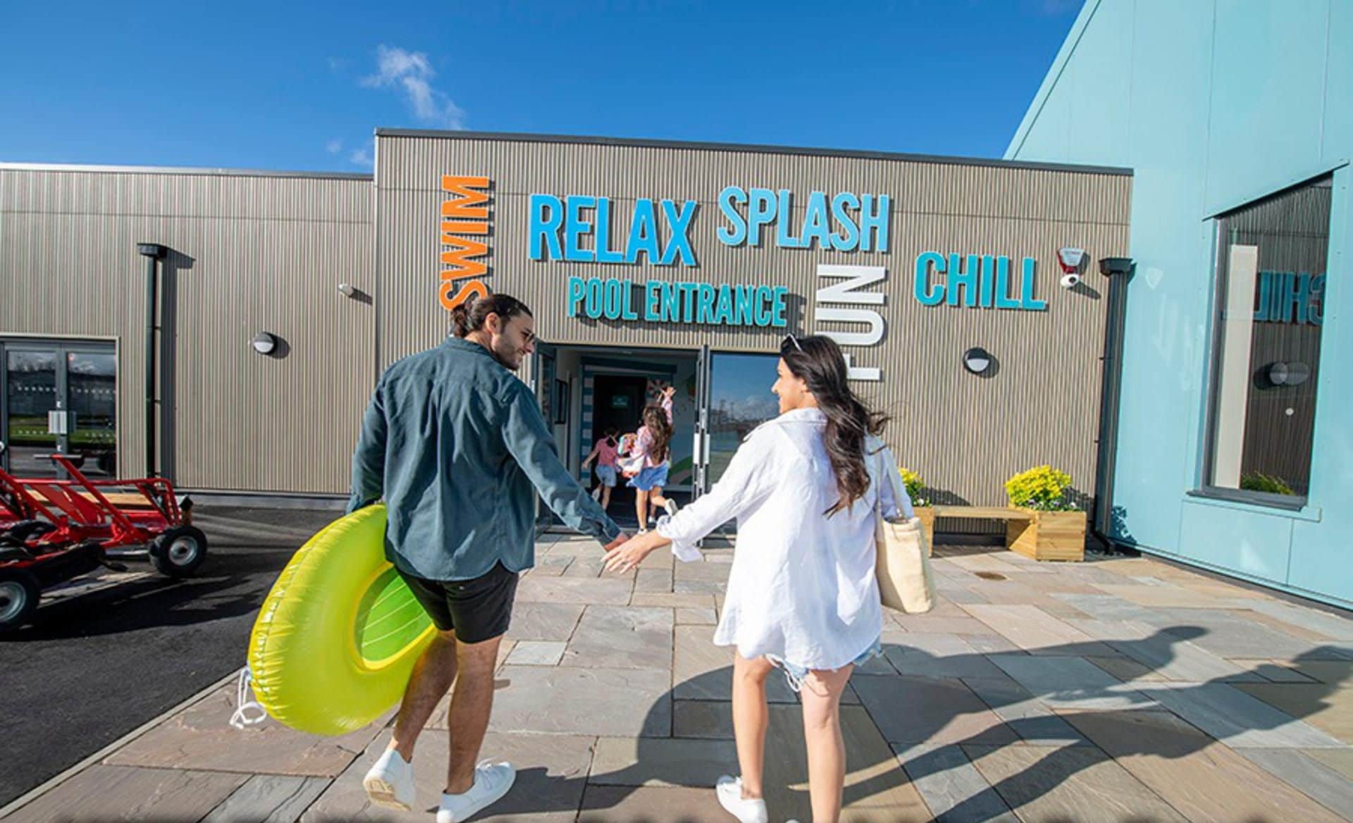 A building with a sign reading "RELAY SPLASH POOL ENTRANCE" and "CHILL".