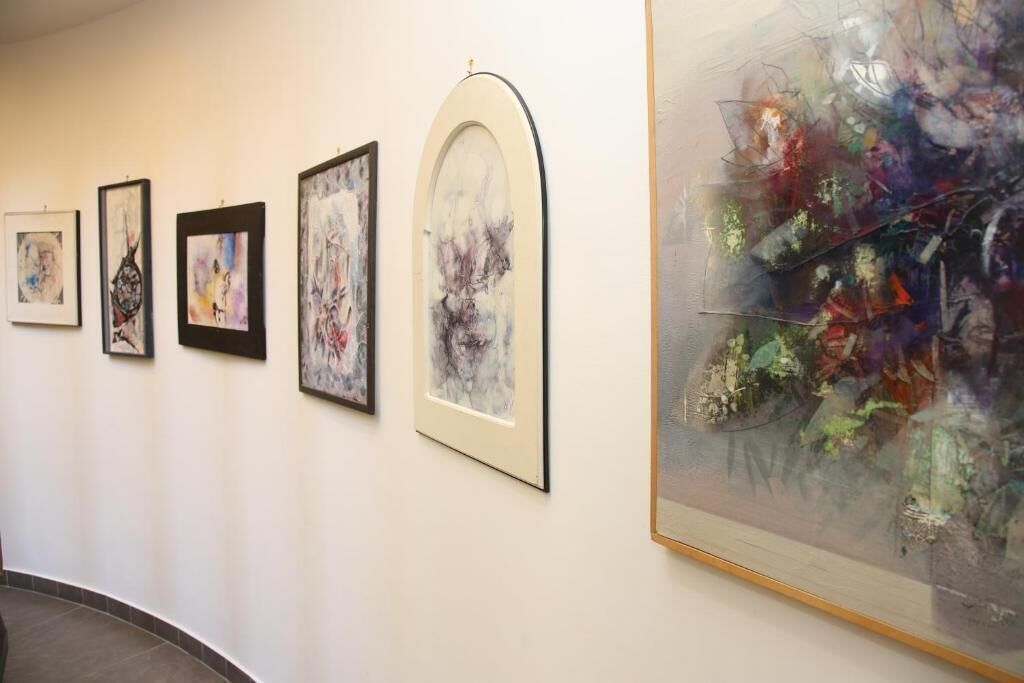 A gallery with framed artworks on the wall.