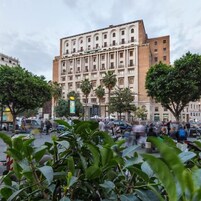 Un edificio a più piani con uno stile architettonico classico, caratterizzato da una facciata simmetrica e balconi finestre regolarmente distanziate.