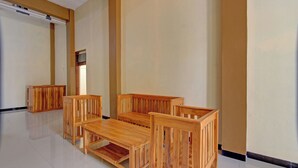 Una habitación con un banco de madera, una mesita y un armario.