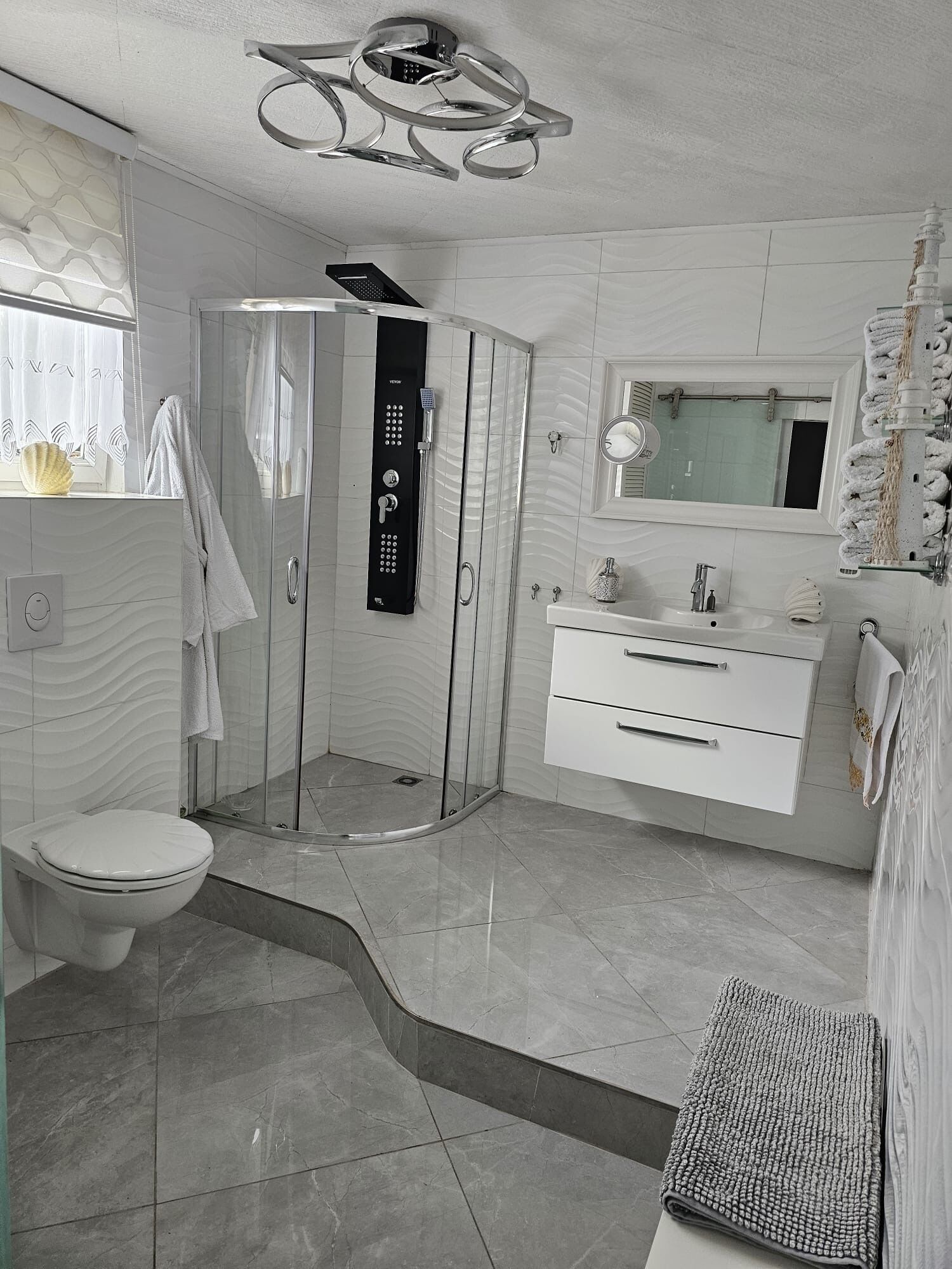 Une salle de bain moderne avec une douche à parois de verre, des toilettes, un lavabo et un meuble-lavabo.