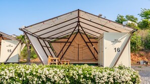 A tented structure with a triangular roof, numbered units 15 and 16, and a small wooden table. - Taean Bibi Artglamping (Taean)