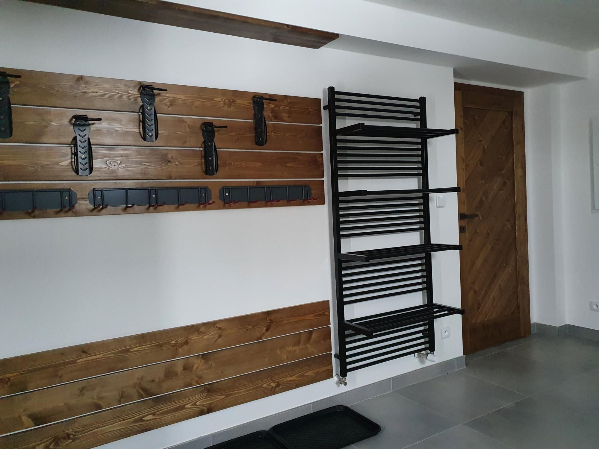 Un interior moderno con un panel de madera y una estantería de metal negro.