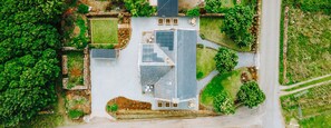 Vue aérienne d’une propriété dotée d’une cour intérieure, d’un espace verdoyant et d’une allée pavée.