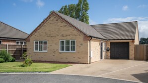A single-story house with a brick exterior, a front garage, and a well-maintained lawn.