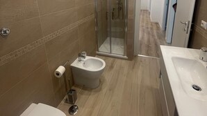 A modern bathroom with a shower, bidet, and two sinks. - Walking distance from Vomero, metro within walking distance in area full of clubs.  (Napoli)