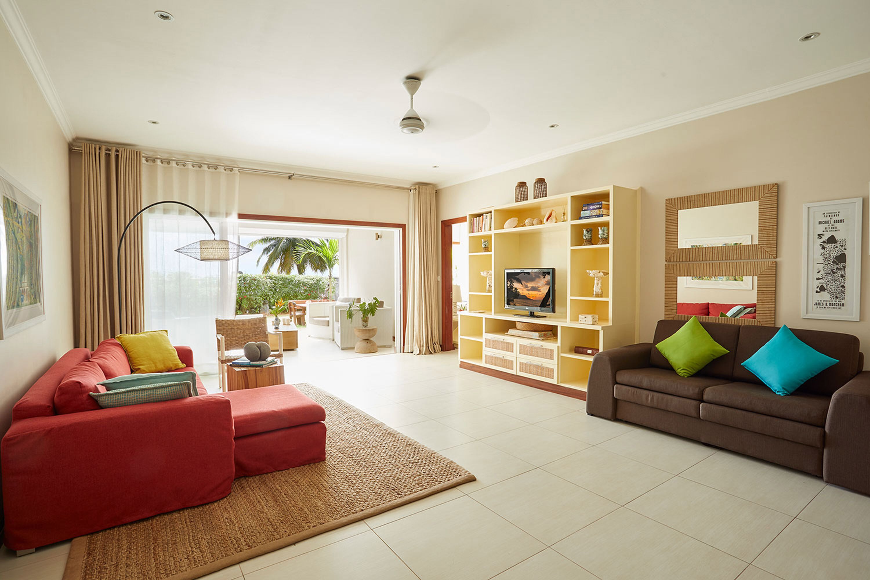 A living room with a red sofa, a brown sofa, and a bookshelf.