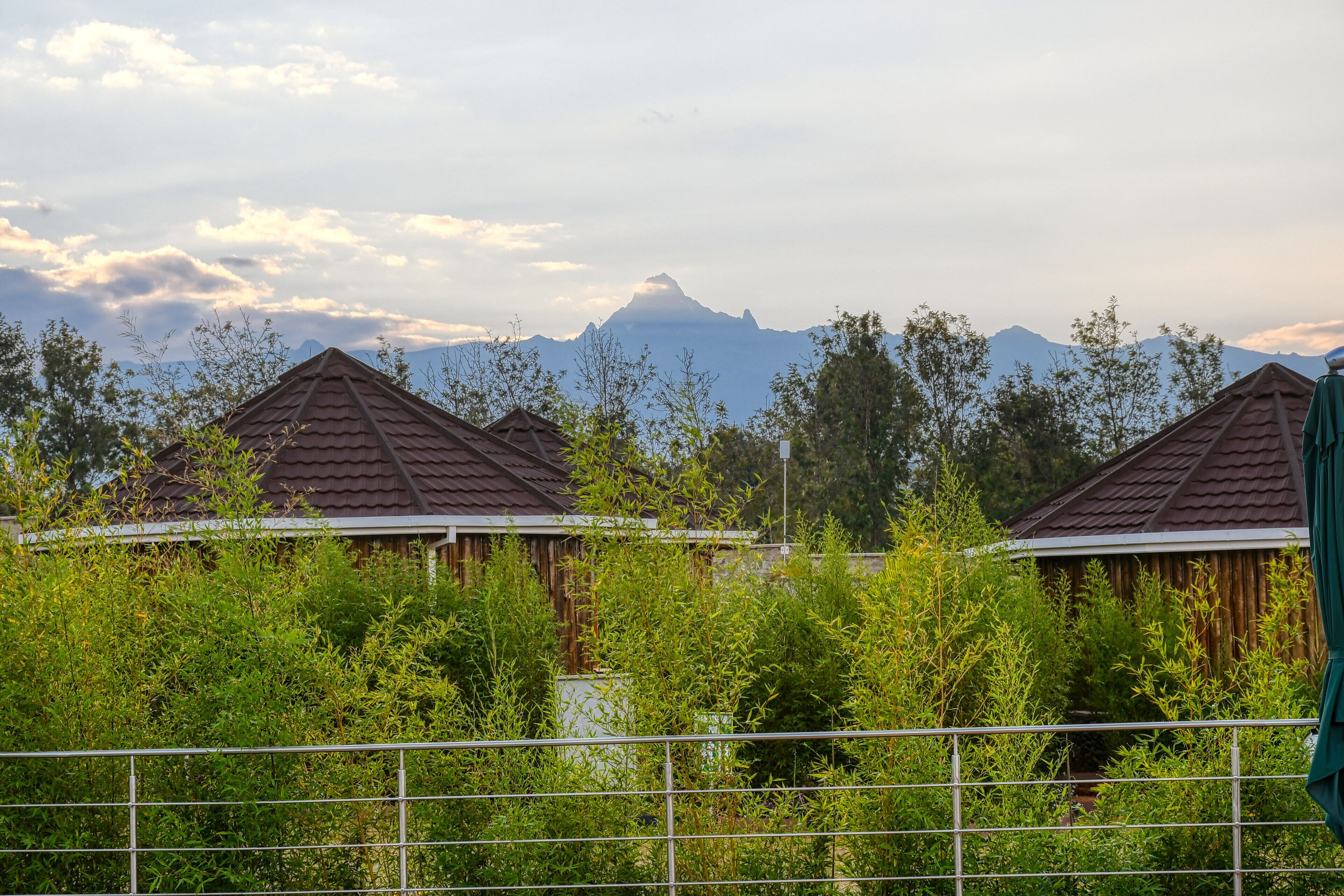 A row of wooden cabins with a mountain backdrop.