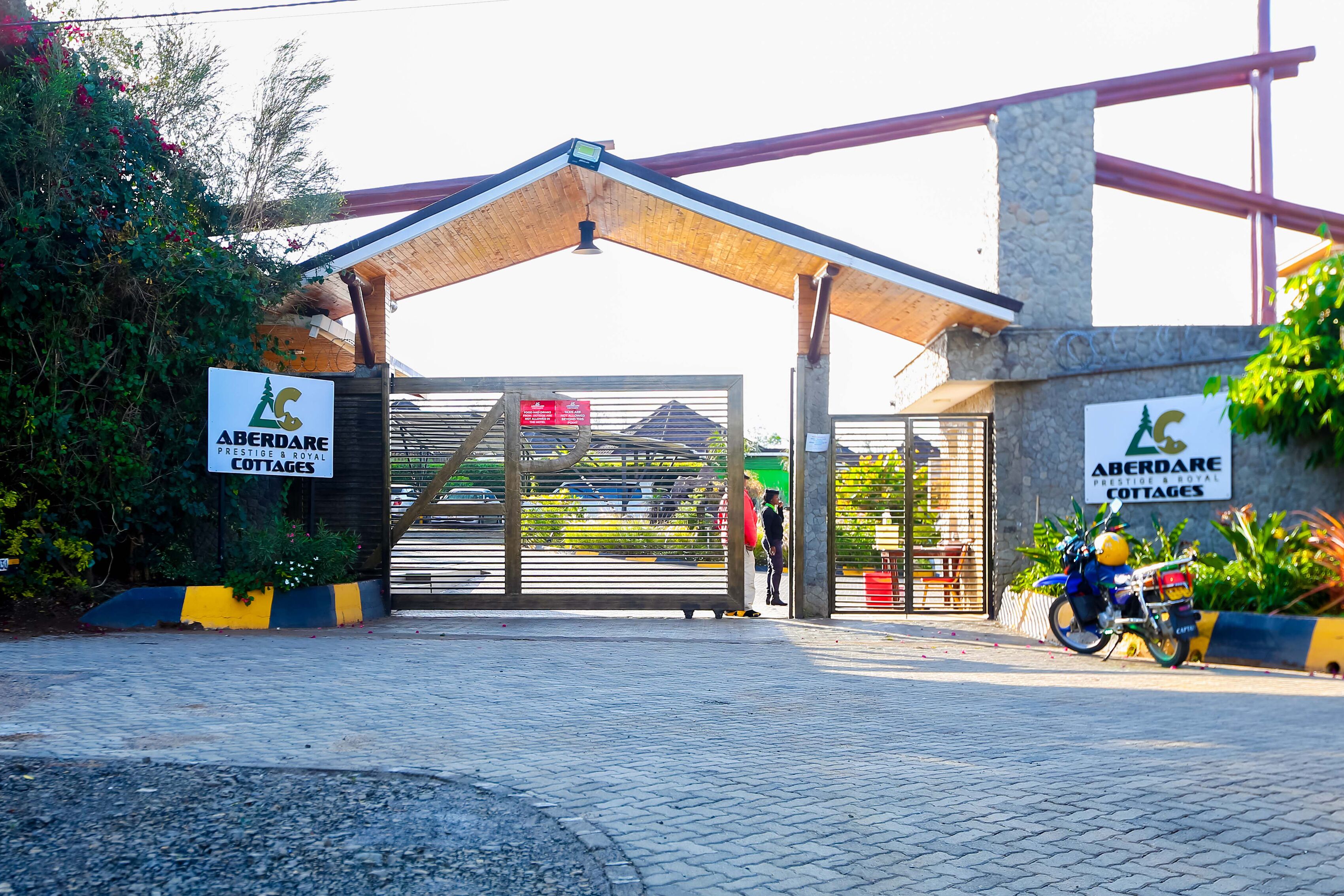 La entrada a Aberdare Cottages, con un paseo techado y una motocicleta estacionada cerca.