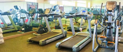 Un gimnasio con cintas de correr y equipo de ejercicio.