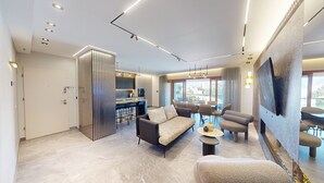Una sala de estar moderna con un sofá, sillones y una zona de comedor con una mesa y sillas.