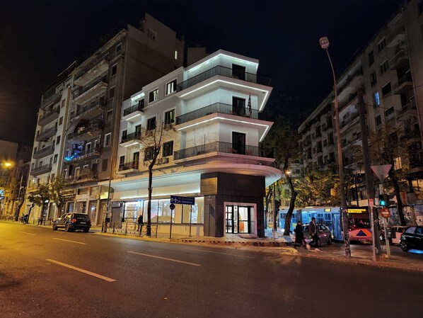 Un edificio moderno a più piani con balconi, ingresso a livello strada e una bandiera ben visibile.
