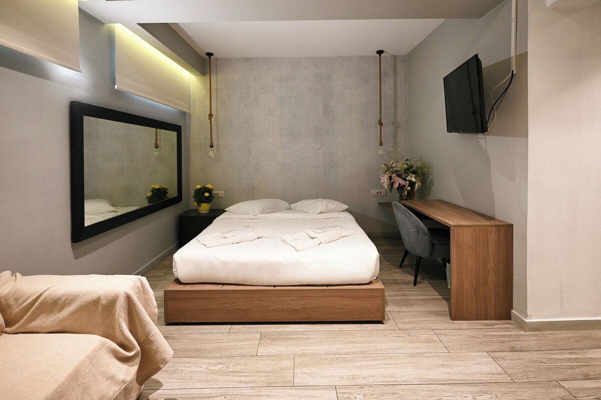 Una camera da letto moderna con un letto grande, un comodino e una scrivania con una sedia.