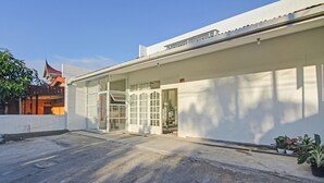 Un bâtiment moderne doté d’un toit plat, de grandes fenêtres en verre et d’un sol en béton.