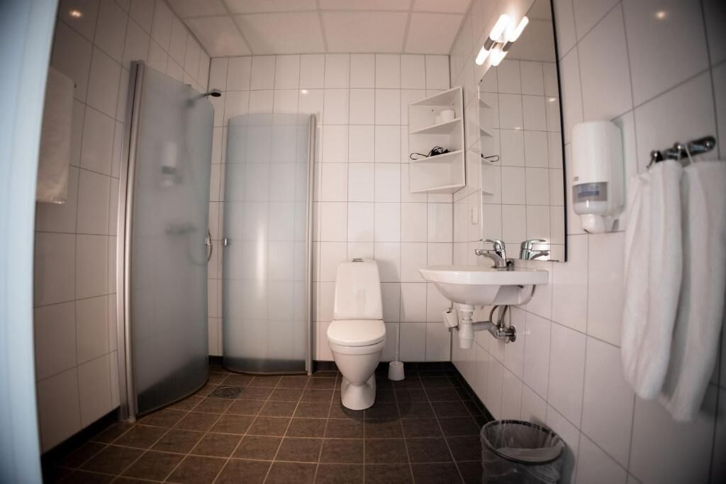 A modern bathroom with a toilet, sink, and shower.