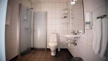 A modern bathroom with a toilet, sink, and shower.