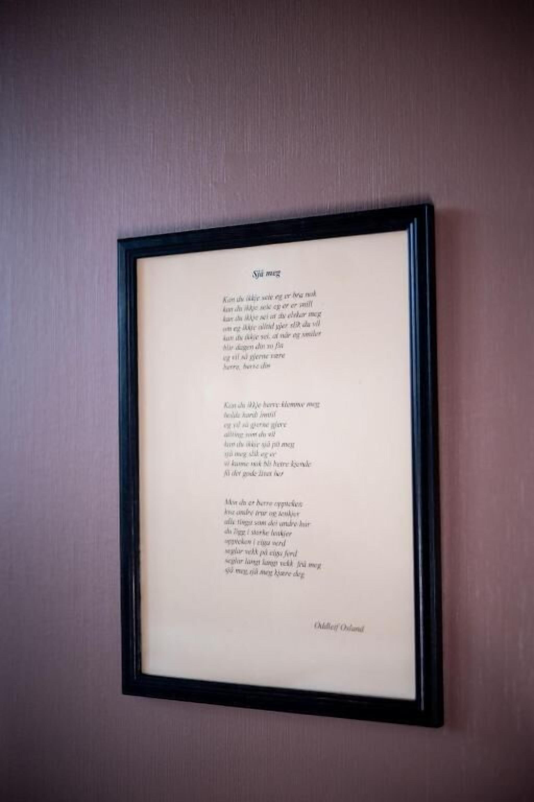 A framed poem titled "Sjáeg" on a wall.