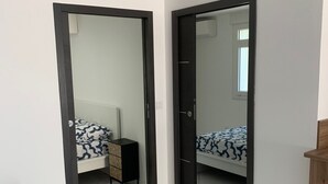 Ein modernes Zimmer mit zwei Betten, einem kleinen Schreibtisch und einem Stuhl.