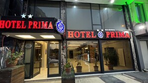 The exterior of Hotel Prima with a prominent sign, large windows, and potted plants. - Hotel Prima (Istanbul)