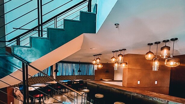 Ein modernes Interieur mit Treppe, Bar und Sitzgelegenheiten.