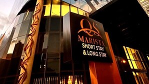 Ein modernes Gebäude mit einer geometrischen Fassade und einem Schild mit der Aufschrift 'Marist Short Stay & Long Stay'.