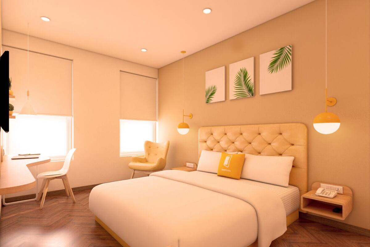 A modern bedroom with a large bed, a desk, and a chair.