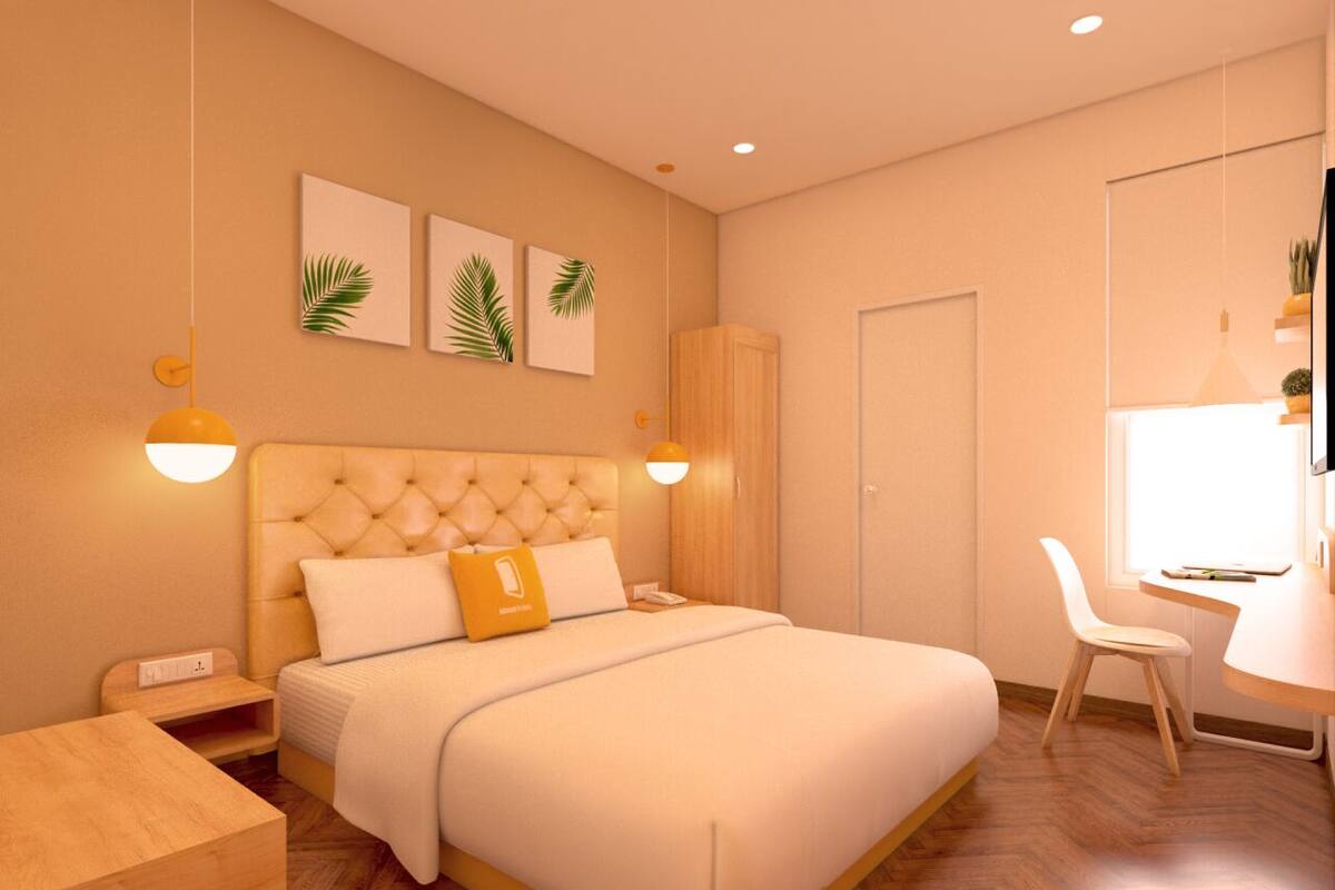 A modern bedroom with a large bed, bedside tables, a desk, and a chair.
