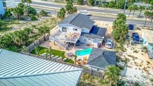 A two-story house with a swimming pool, a fenced yard, and a street view.