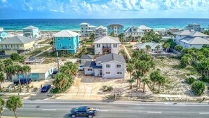 A coastal residential area with houses, a beach, and a road.