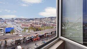 A cityscape with a marina, a busy road with buses and cars, and a clear sky. - Chic Modern Lofts by Wonderful Italy (Genoa)