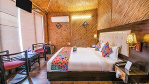 Habitación decorada en madera con cama, escritorio, sillas y televisor.