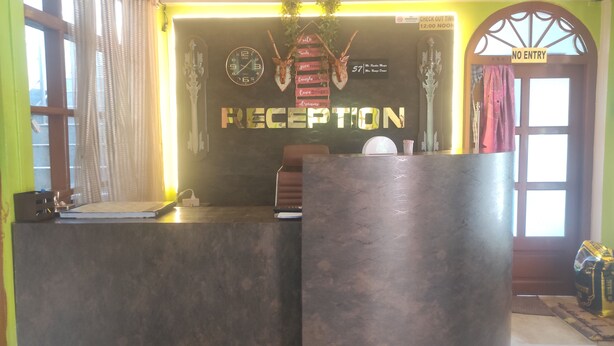 Ein Empfangsbereich mit einem 'RECEPTION'-Schild, einer Uhr und einem Schild mit der Aufschrift 'CHECK OUT TIME 12:00 NOON'.