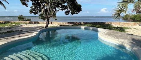 Una piscina al aire libre, sillones reclinables de piscina