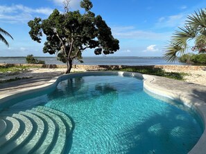 Una piscina al aire libre, sillones reclinables de piscina