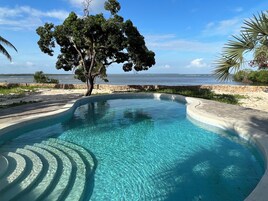 Una piscina al aire libre, sillones reclinables de piscina