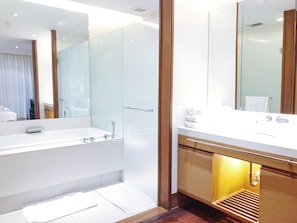 Une salle de bain moderne avec un grand miroir, une baignoire et un meuble-lavabo avec un évier.