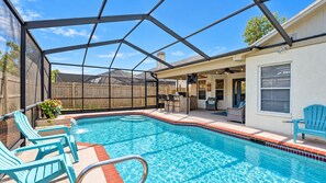En swimmingpool med overdækket område, stole og terrasse.