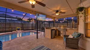 A backyard with a swimming pool, a barbecue grill, and a dining area with outdoor furniture. - Brandon Home | Heated Pool | Sleeps 10 (Brandon)