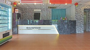 A reception area with a marble counter, a push cart with beverages, and flags of Malaysia, the USA, and China. - OYO 90846 Hotel Akasia (Sungai Petani)