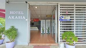 The entrance to Hotel Akasia with a 'Welcome' mat, potted plants, and a CCTV monitoring sign. - OYO 90846 Hotel Akasia (Sungai Petani)