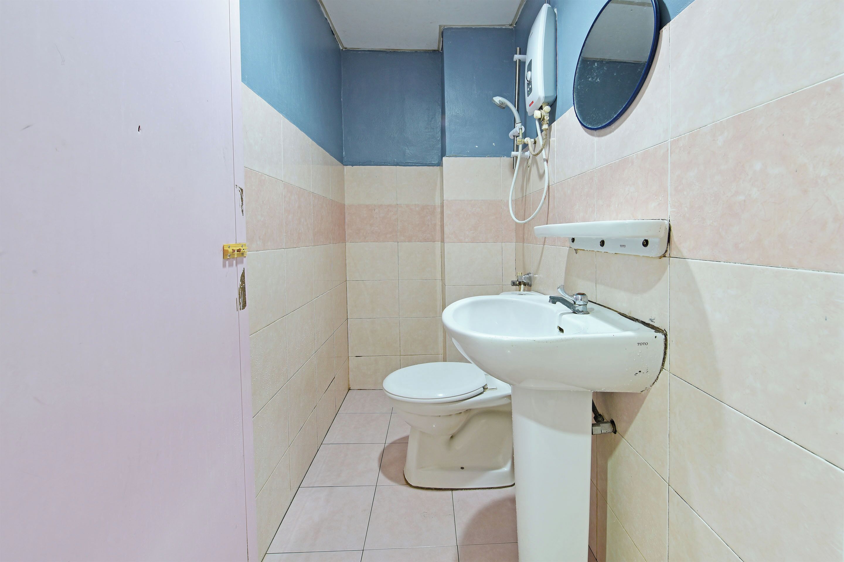 A small bathroom with a toilet, sink, and a mirror.