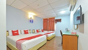 A hotel room with two beds, a wooden floor, a desk with a mirror, and a wall-mounted TV. - OYO 90846 Hotel Akasia (Sungai Petani)