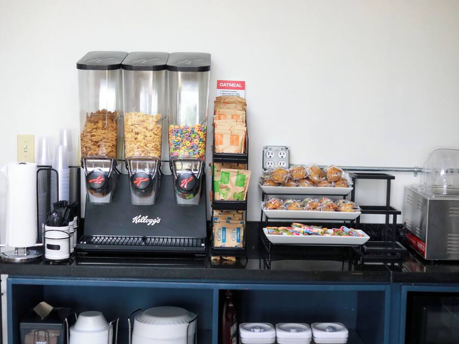 Una estació de servei de cafè amb diversos dispensadors de begudes, varietat de petits aperitius i una màquina de cafè de la marca Kellogg's.