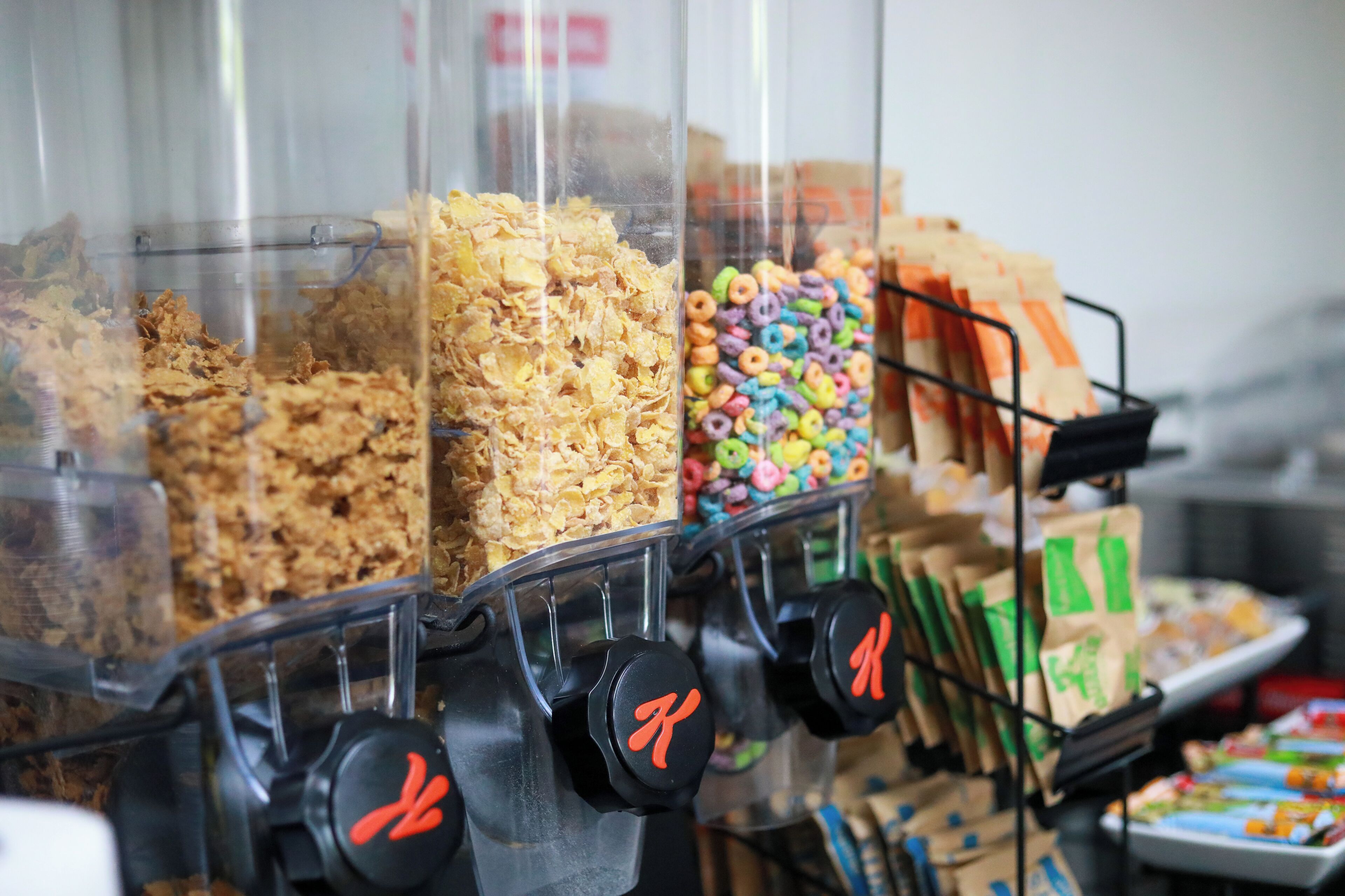 A cereal dispenser with various cereals and snacks.